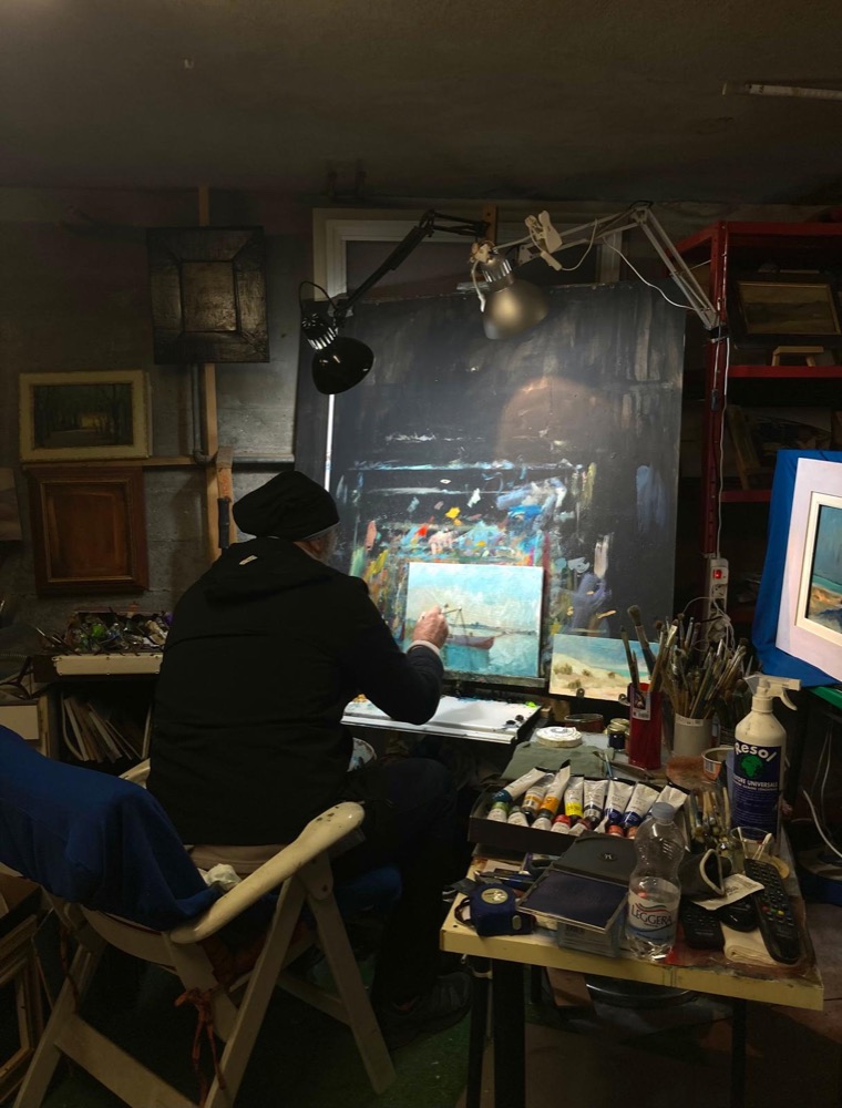 Christian Nardi al lavoro nel suo studio, di spalle, davanti al cavalletto.