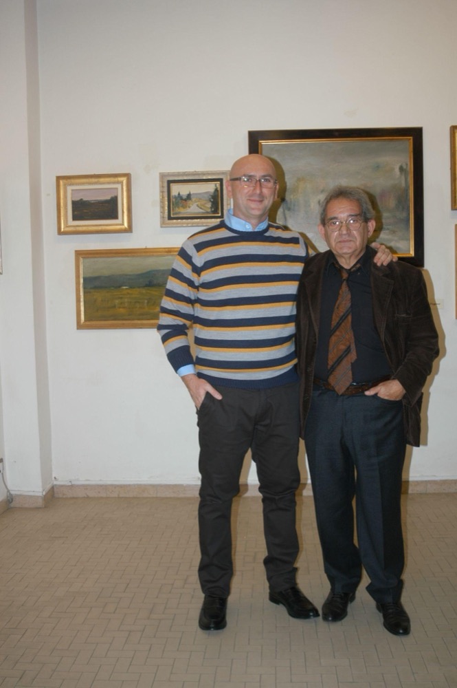 Lo studio dell’artista: tavolozza, tubetti di colore e tele appoggiate alle pareti.
